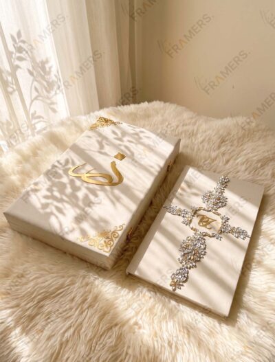 Ivory crystal Nikkah booklet with initials beside a matching ivory box with gold calligraphy