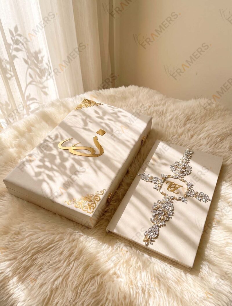 Ivory crystal Nikkah booklet with initials beside a matching ivory box with gold calligraphy