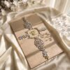 Soft gold silk Nikkah booklet cover with a clear crystal cross brooch and gold initials